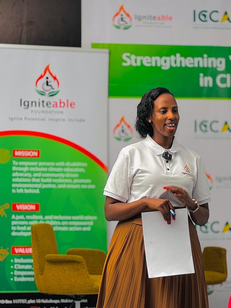 A facilitator smiles while presenting beside the Igniteable Foundation banner.