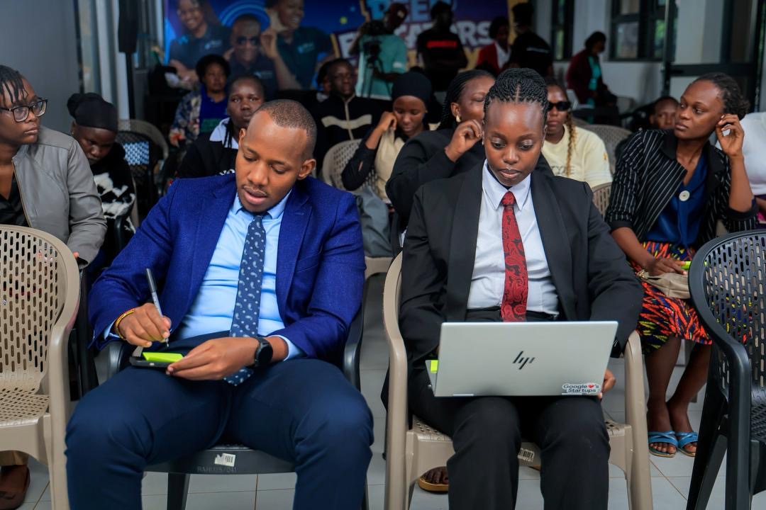 Participants take notes and work on laptops during a session.