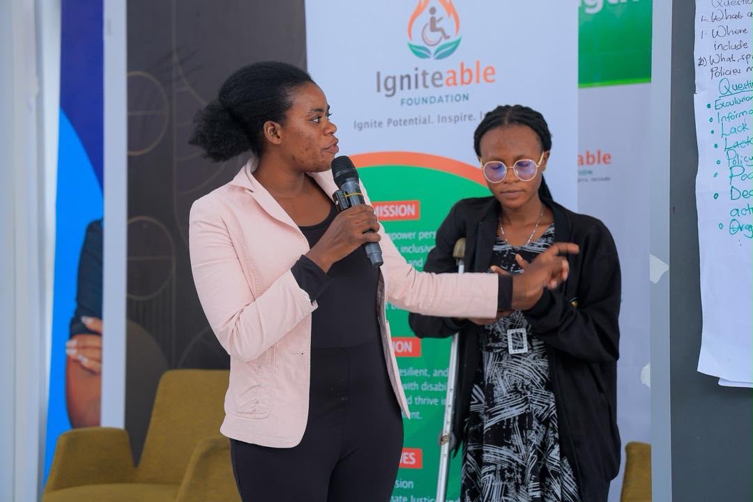 Two participants, one using a crutch, present group findings to the room.