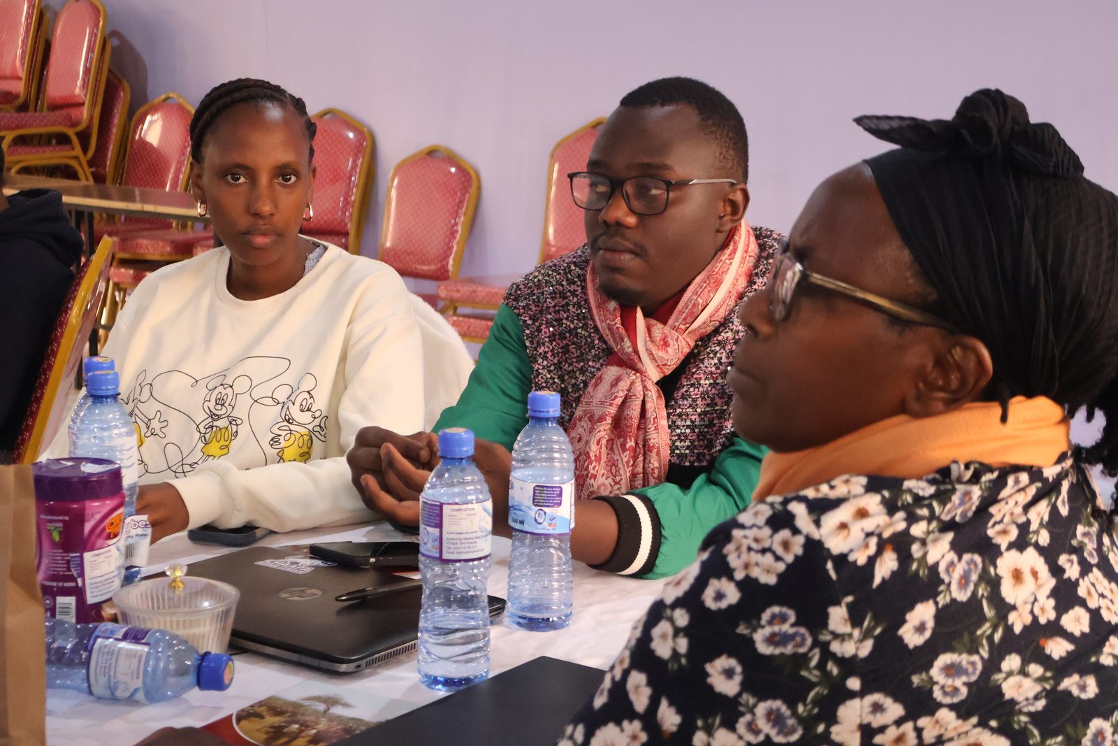 Participants listen attentively during a workshop session, one wearing an Igniteable Foundation polo shirt.