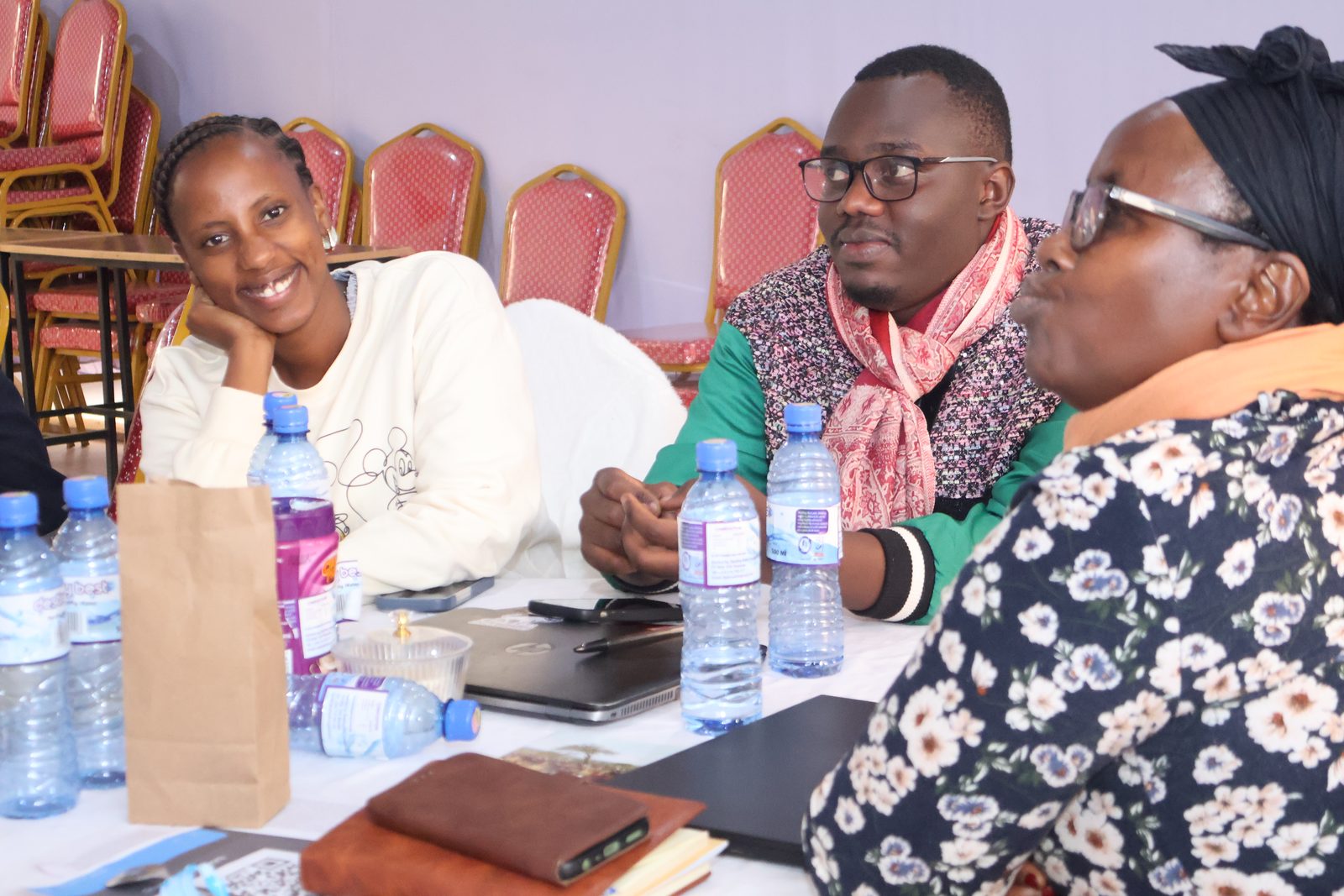 Three participants seated at a table in conversation during a breakout discussion.